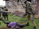 a Kenyan policeman with a G3 rifle beating an unarmed man