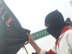 Zapatista teacher grips the black and red flag of the EZLN