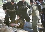 Israeli policemen arrest a protester