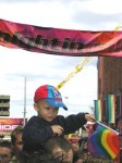 Young child waves a rainbow flag in front of the Nightingale club