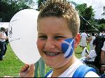 Boy with Scotland flag painted on his face and Make Poverty History balloon