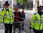 police need help moving crowd control barriers - luckily a clown assists