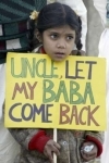 A girl holds a placard as she protests against the disappearance of her father
