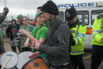 Police push demonstrators to one side to let a car enter