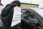 A demonstrator talks to a driver leaving the site
