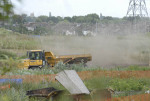 More dust with houses nearby visible in background