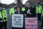 In front of the Police along the edge of the entry road