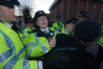 Police hold Pauline Campbell as she tries to go through and show her poster
