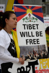 A Tibetan woman carries a Free Tibet poster during a protest rally Monday, March