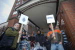 Demonstrators hold placards outside the building