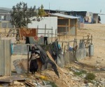 Bedouin woman outside her home in Qiryeh al-Sir