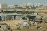 Unrecognized Bedouin settlement in the shadow of Be'er Sheva prison and highrise