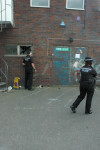 Police hang about while colleagues search the building