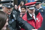 An officer starts pushing people