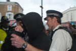 Police grab man when he fails to remove mask