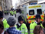 A view over heads, looking towards Bank of England at the layered police lines.