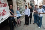 Two people read leaflets and talk to the protesters