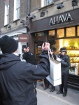 Pro-ahava counter-demonstrator holds aloft an AHAVA shopping bag