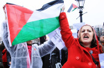Two women raise a Palestinian flag in Trafalgar Square