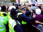 A tussle at the back of the building between police and activists.