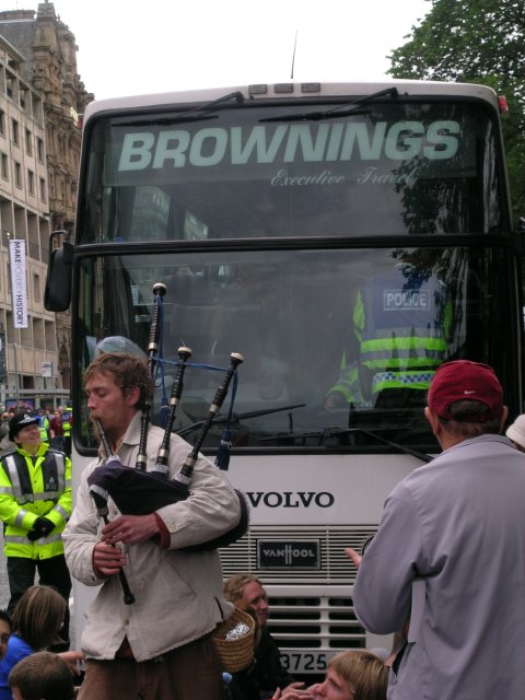 A lone piper plays as people try to get the buses moving