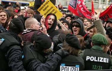 Demonstrators face German riot policemen as they take part in a rally