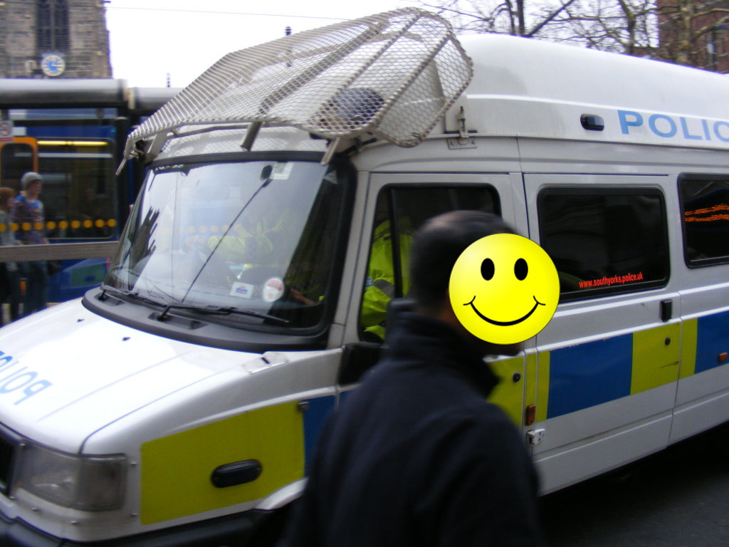 the lock-up van leaving, faces obscured to protect the inocent