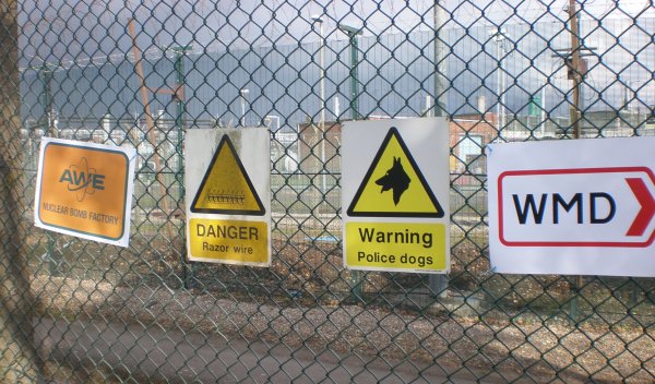 Warning signs punctuate the fence, and extra ones are added