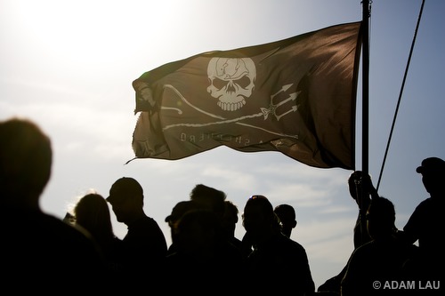 Sea Shepherd crew beneath the Jolly Roger flag on the ship's bow