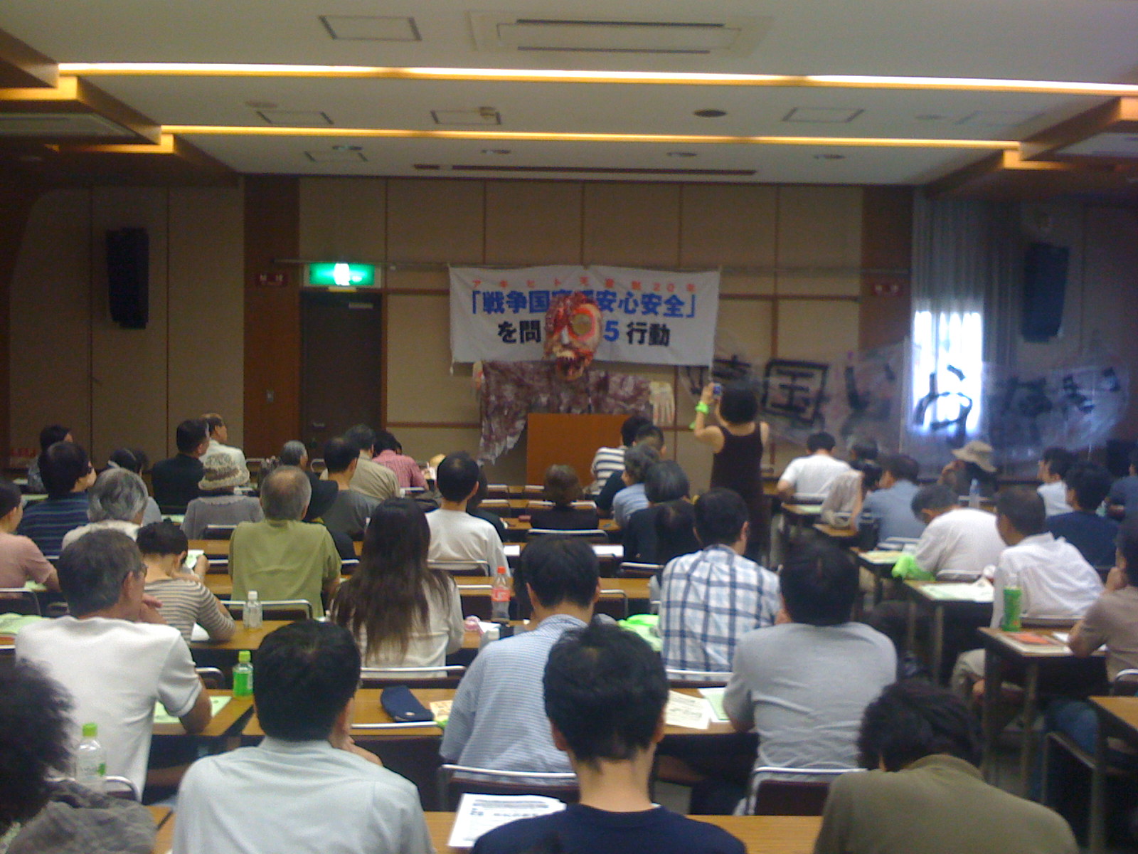 Photo of a speech using a giant puppet which was also used to protest with.