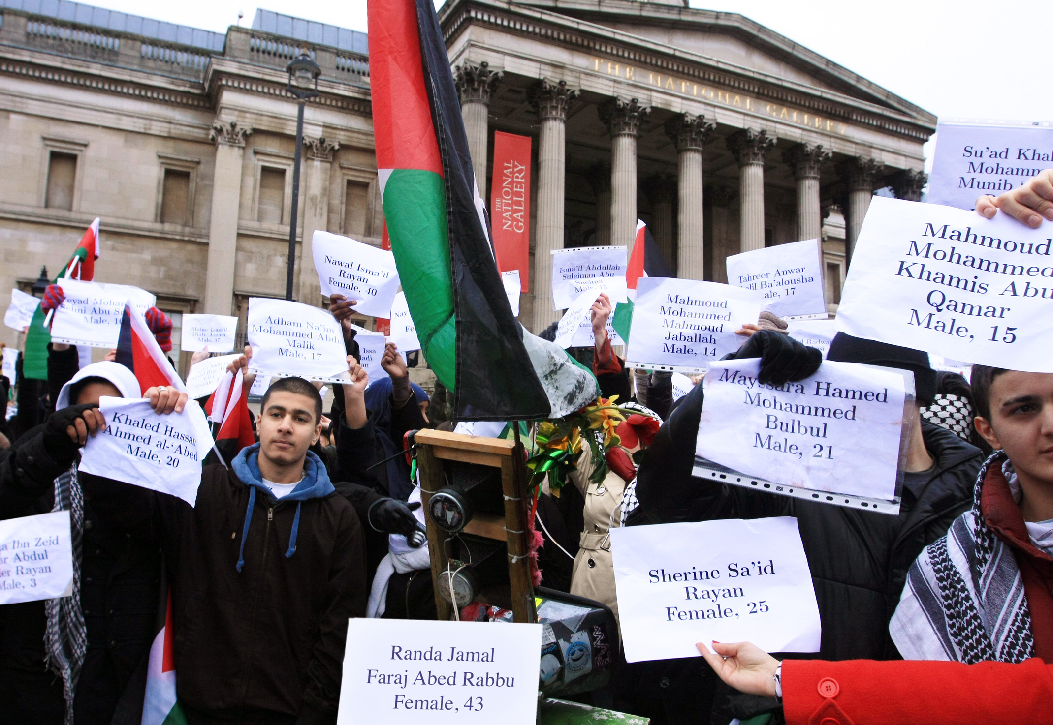 Palestinian supporters hold the names of some of the 1417 dead