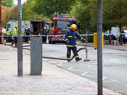 A fireman apparently flushing out a drain underneath East Road.