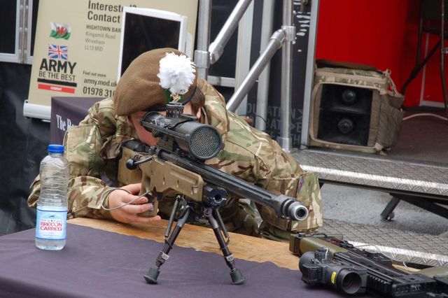 Young army cadet tries out a sniper rifle